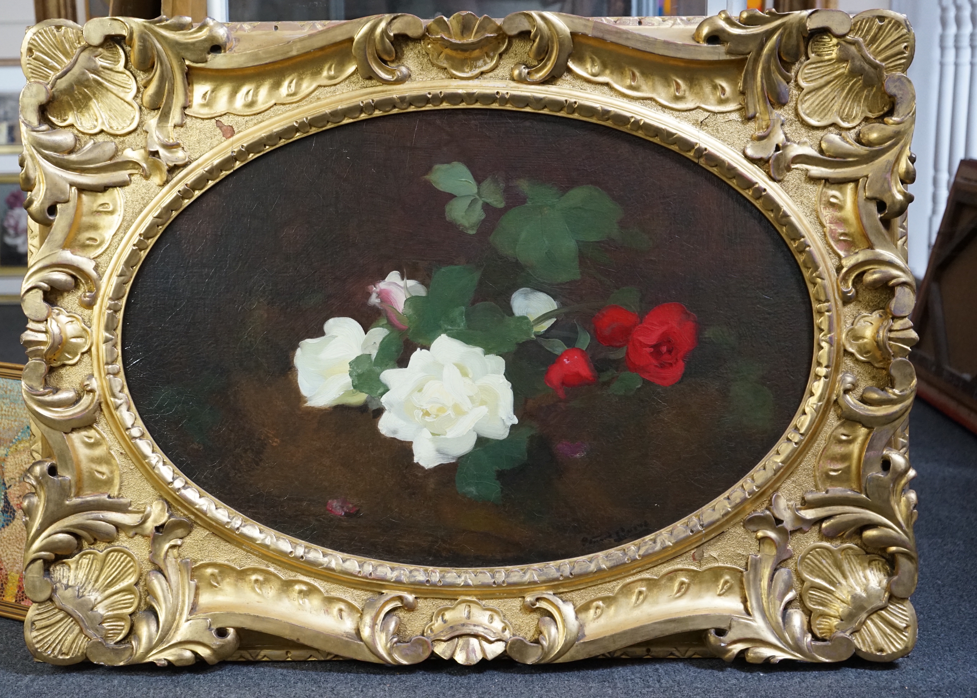 Stuart Park (Scottish, 1862-1933), Red and white roses upon a ledge, oil on canvas, oval, 50 x 75cm, in ornate giltwood frame